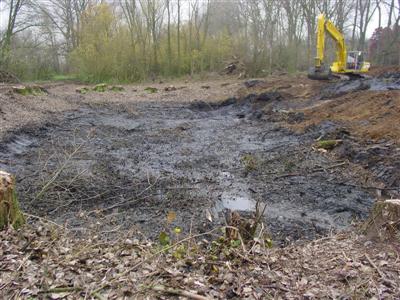 Vierkante vijver na het rooien en leegpompen